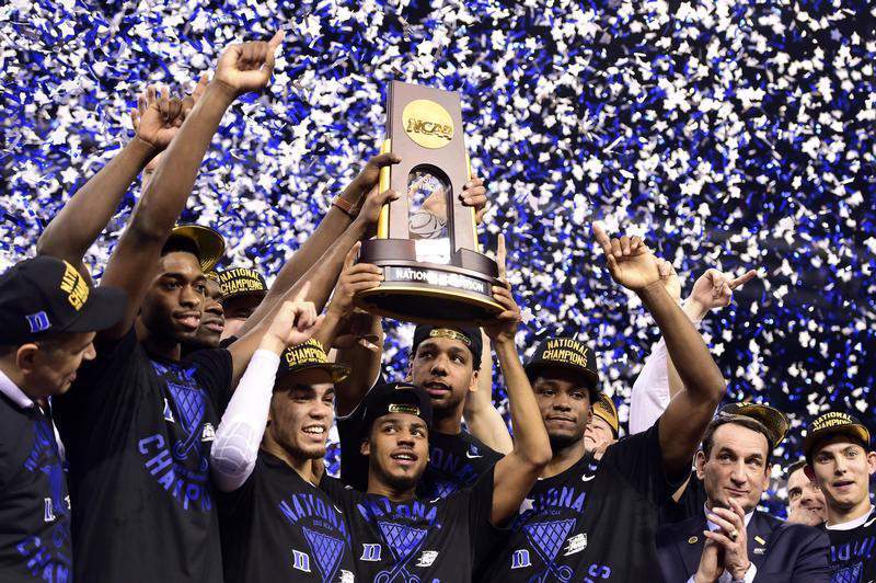 Apr 6, 2015; Indianapolis, IN, USA; Duke Blue Devils guard Quinn Cook (middle) and teammates hoist the NCAA championship trophy after defeating the Wisconsin Badgers in the 2015 NCAA Men's Division I Championship game at Lucas Oil Stadium. Mandatory Credit: Bob Donnan-USA TODAY Sports - RTR4WB65